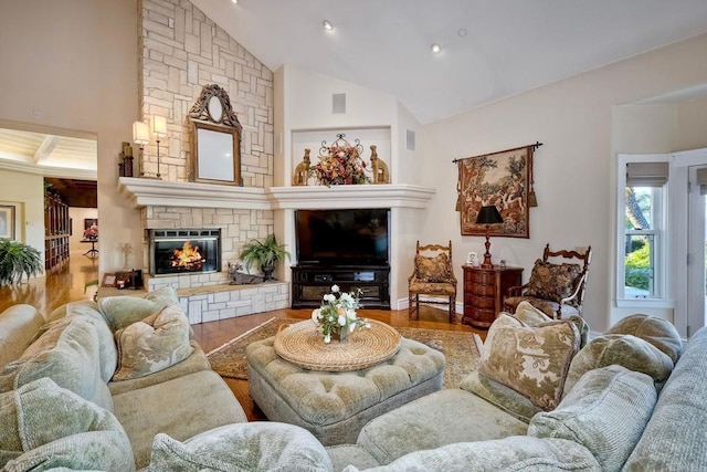 living room with hardwood / wood-style floors, a fireplace, and high vaulted ceiling