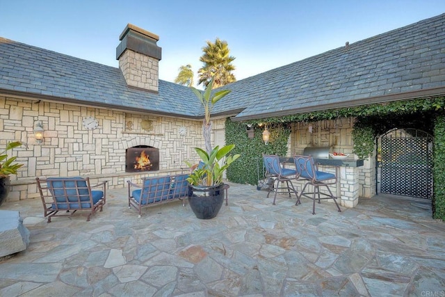 view of patio with an outdoor stone fireplace