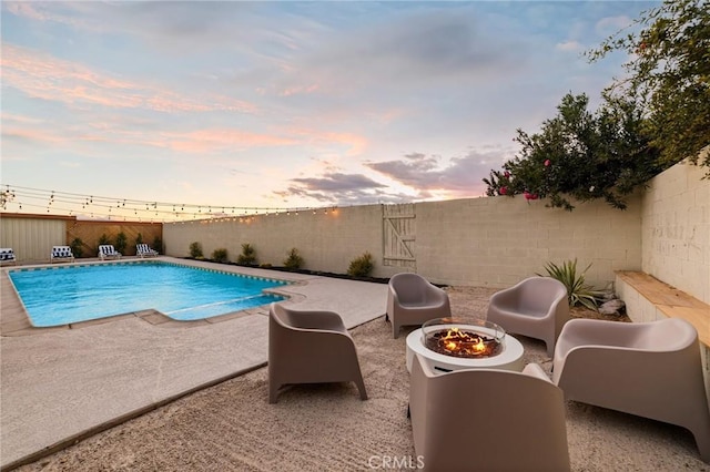 pool at dusk with a patio