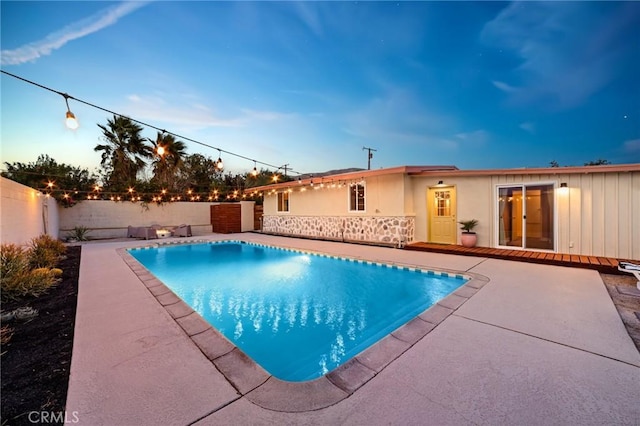 pool at dusk with a patio