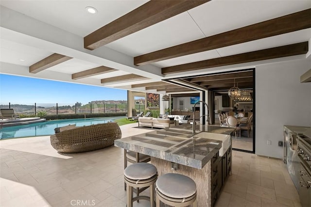 view of patio with outdoor dry bar, an outdoor hangout area, fence, a sink, and an outdoor pool