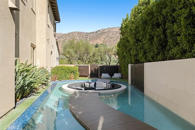 view of swimming pool with a fenced backyard, a mountain view, and a fenced in pool