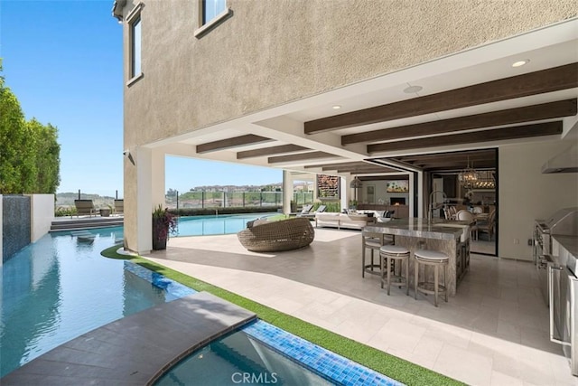 pool with a patio, an outdoor kitchen, and outdoor wet bar