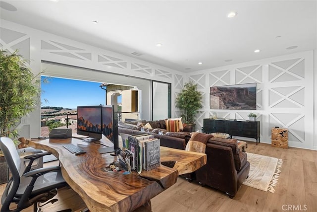 living area with recessed lighting, visible vents, a decorative wall, and light wood-style flooring