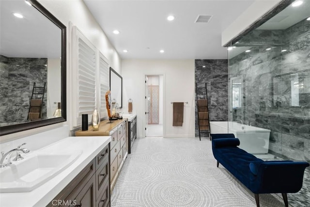 bathroom with a freestanding tub, recessed lighting, visible vents, vanity, and tile patterned floors