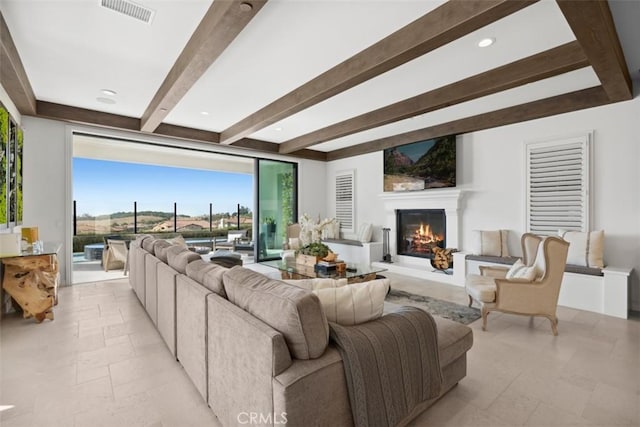 living room with recessed lighting, stone tile floors, visible vents, beamed ceiling, and a glass covered fireplace