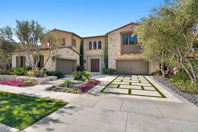 mediterranean / spanish-style house featuring concrete driveway, stone siding, and stucco siding