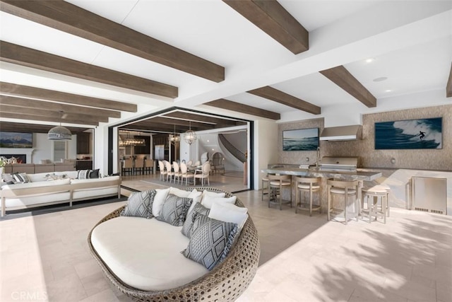 living room with beam ceiling and an inviting chandelier