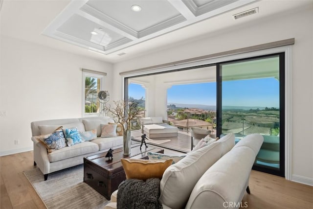 living area featuring coffered ceiling, visible vents, baseboards, light wood-type flooring, and beam ceiling