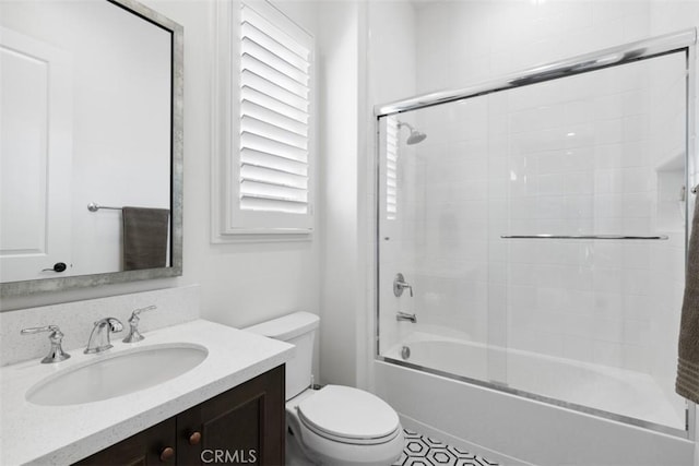 bathroom with toilet, bath / shower combo with glass door, and vanity