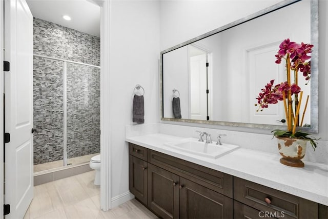 full bathroom featuring vanity, a shower stall, and toilet