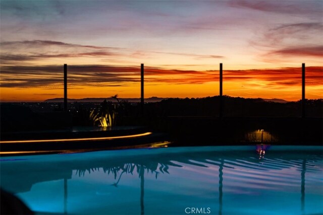 view of pool at dusk