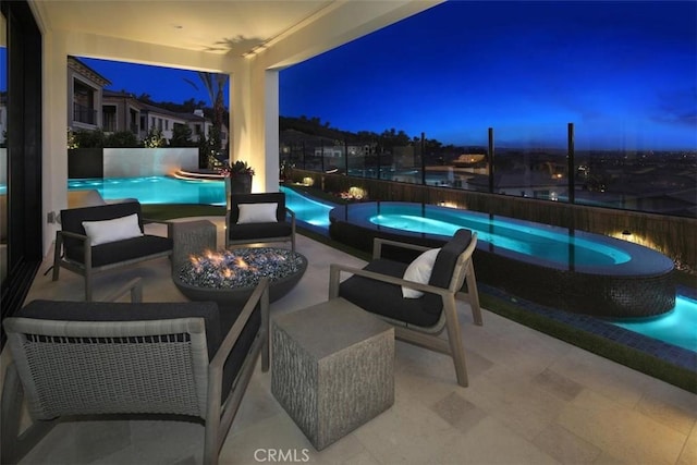 view of patio / terrace with a pool with connected hot tub and a fire pit