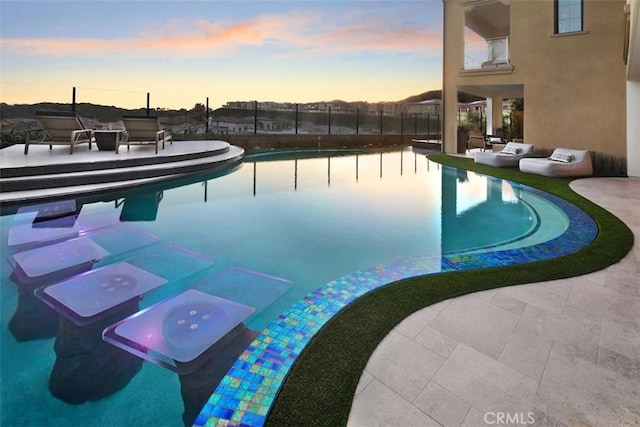 outdoor pool featuring a patio area and fence