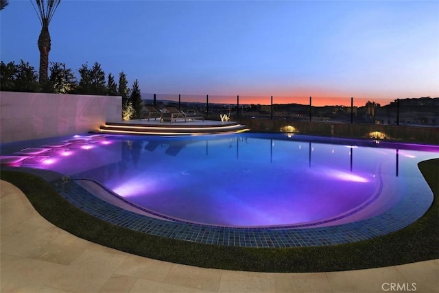 pool at dusk featuring fence and a fenced in pool