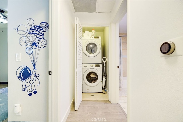 washroom featuring stacked washer / dryer and light wood-type flooring