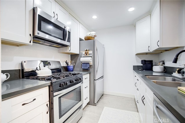 kitchen featuring stainless steel appliances, sink, and white cabinets