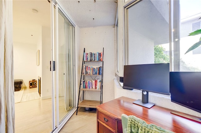 office area featuring a textured ceiling and light wood-type flooring