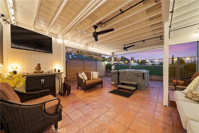 patio terrace at dusk featuring outdoor lounge area, ceiling fan, and a hot tub