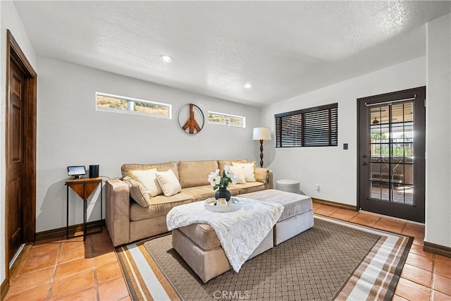 tiled living room featuring a textured ceiling and a healthy amount of sunlight