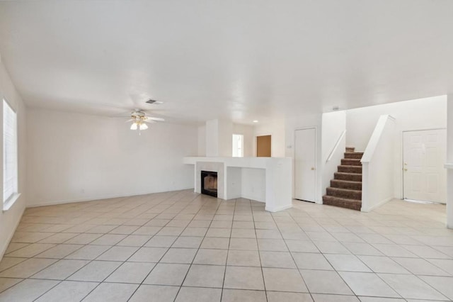 unfurnished living room with a healthy amount of sunlight, light tile patterned floors, and ceiling fan