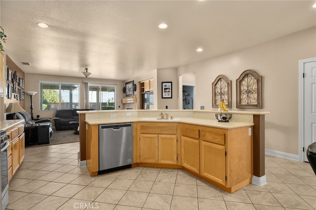 kitchen with light tile patterned floors, stainless steel appliances, and a textured ceiling