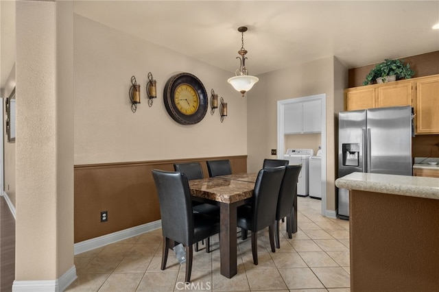 tiled dining area with washing machine and clothes dryer