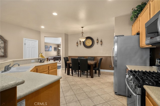 kitchen featuring decorative light fixtures, sink, light tile patterned floors, and stainless steel appliances