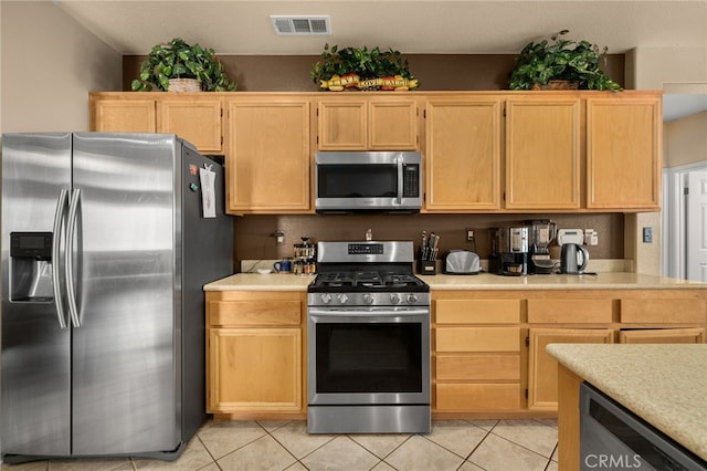 kitchen with appliances with stainless steel finishes, light brown cabinets, and light tile patterned flooring