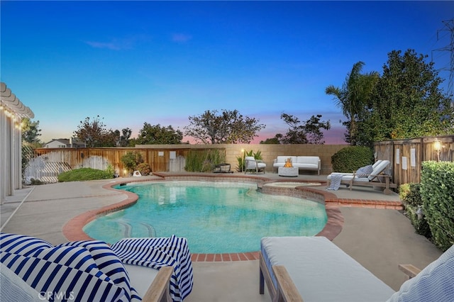 pool at dusk with outdoor lounge area and a patio area