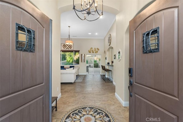 entrance foyer featuring crown molding and a chandelier