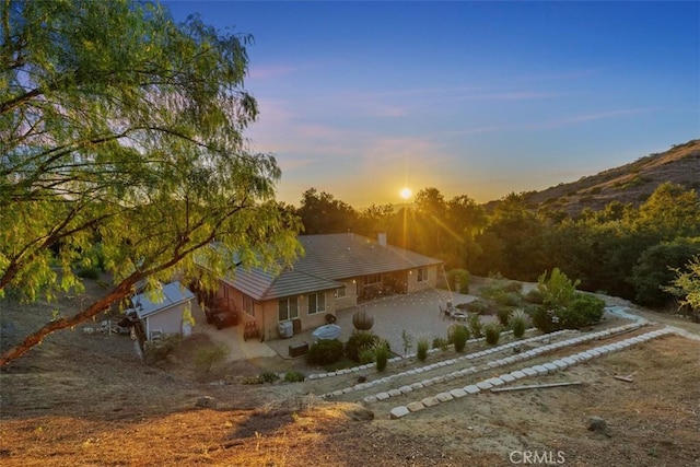 45600 La Cruz Dr, Temecula, CA 92590 - back of property at dusk featuring a patio area, a chimney, a tiled roof, and driveway