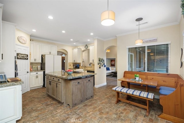 45600 La Cruz Dr, Temecula, CA 92590 - kitchen featuring arched walkways, ornamental molding, brick patterned floors, freestanding refrigerator, and decorative backsplash
