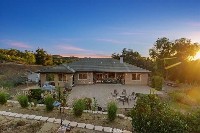 45600 La Cruz Dr, Temecula, CA 92590 - back of house at dusk featuring a patio area, a fire pit, and a chimney