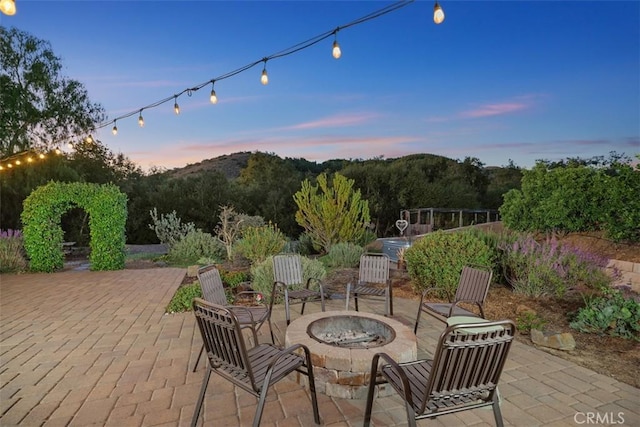 patio terrace at dusk with a mountain view and an outdoor fire pit