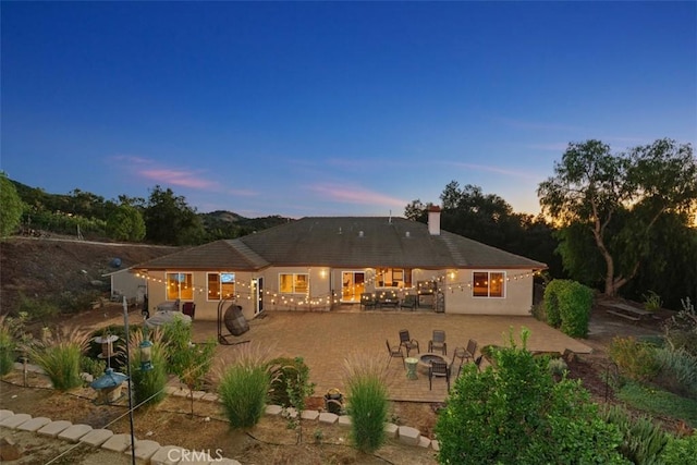 back house at dusk with a patio