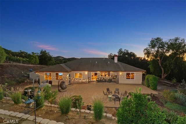 45600 La Cruz Dr, Temecula, CA 92590 - back of property at dusk with a patio and a chimney