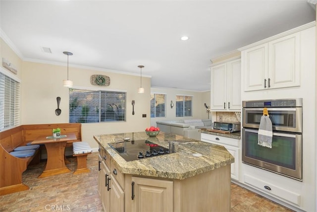 kitchen with pendant lighting, black electric cooktop, a center island, and stainless steel double oven