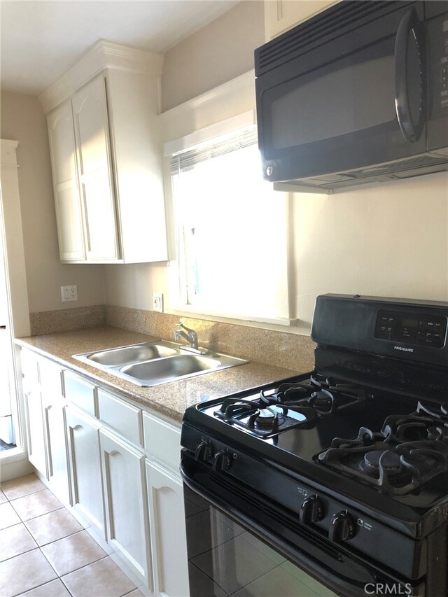 kitchen featuring light tile patterned floors, black appliances, sink, and white cabinets