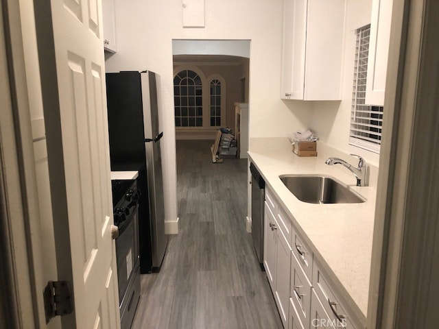 kitchen with white cabinets, light stone counters, dark hardwood / wood-style flooring, appliances with stainless steel finishes, and sink