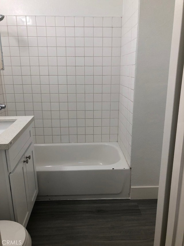 full bathroom with vanity, toilet, hardwood / wood-style flooring, and tiled shower / bath