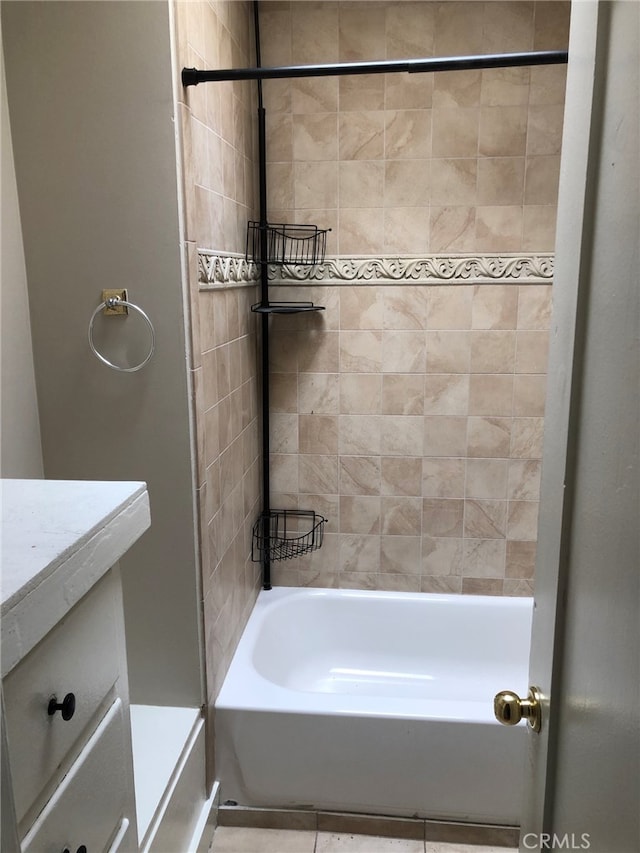 bathroom with vanity, tiled shower / bath combo, and tile patterned flooring