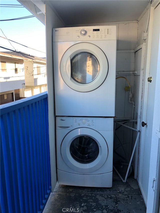 laundry room featuring stacked washer / drying machine