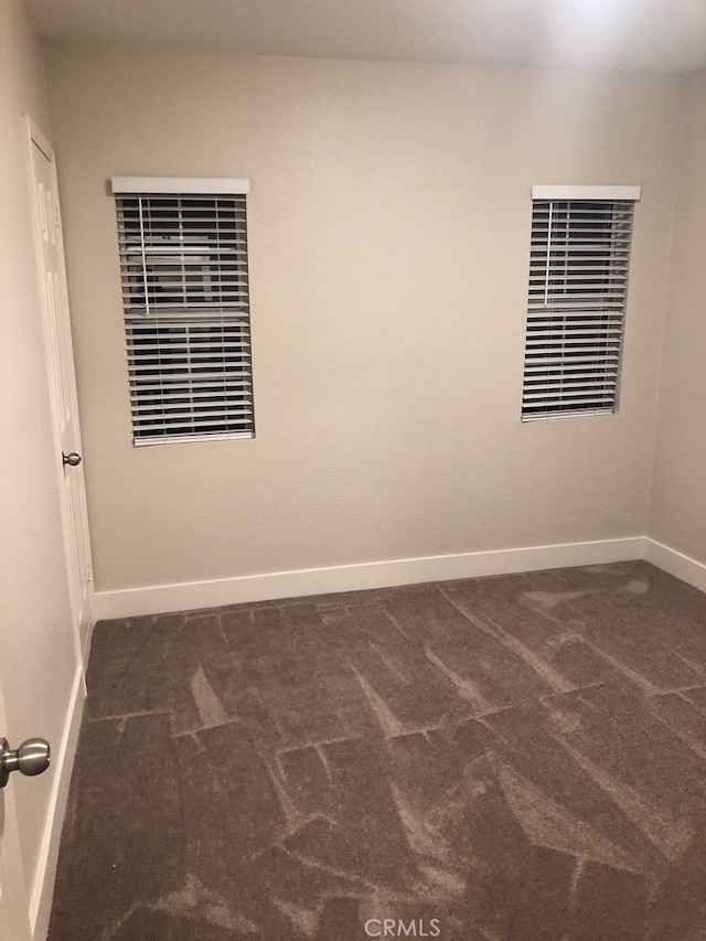 empty room featuring dark carpet