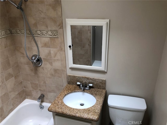 full bathroom featuring toilet, tiled shower / bath combo, and vanity