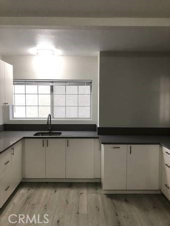 kitchen featuring sink, white cabinets, and light hardwood / wood-style floors