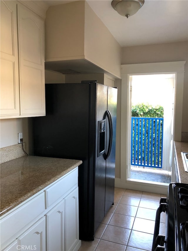 kitchen with white cabinets, black appliances, and light tile patterned floors