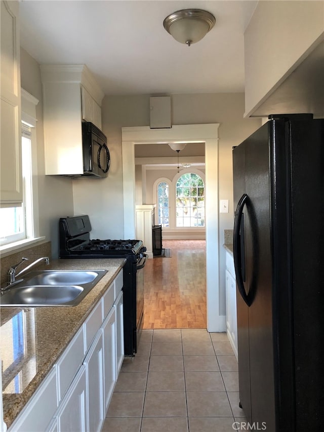 kitchen featuring light hardwood / wood-style floors, black appliances, sink, and white cabinets