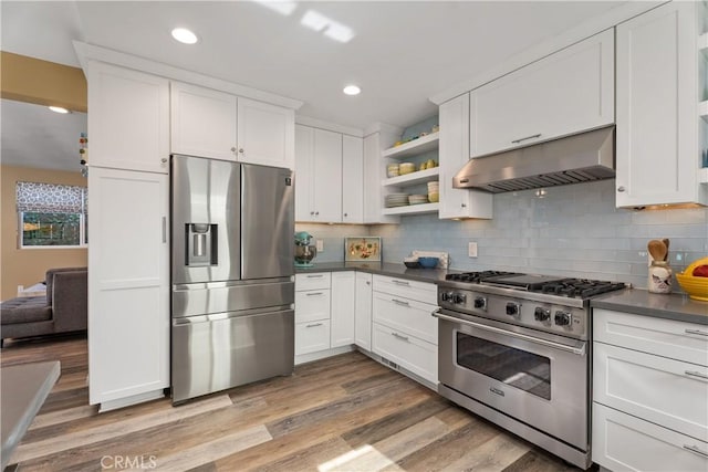 kitchen featuring ventilation hood, appliances with stainless steel finishes, white cabinets, and tasteful backsplash