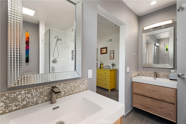 bathroom featuring tile patterned flooring, a shower with shower door, and vanity